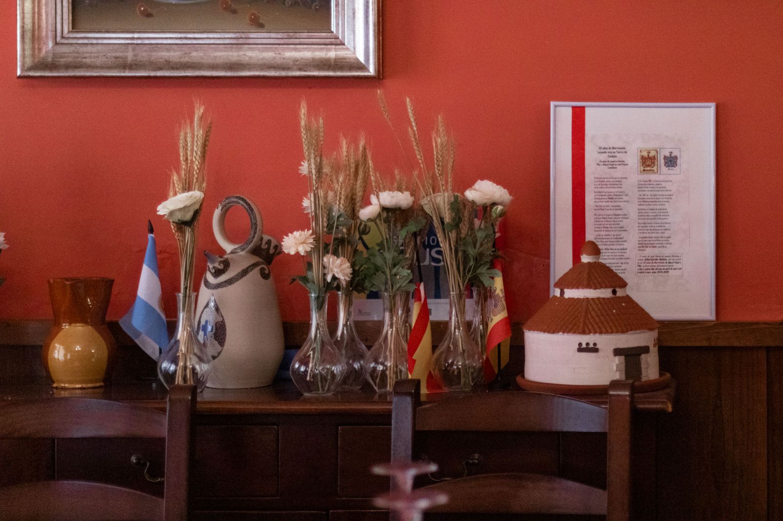 Aparador con espigas de trigo, flores y botijo